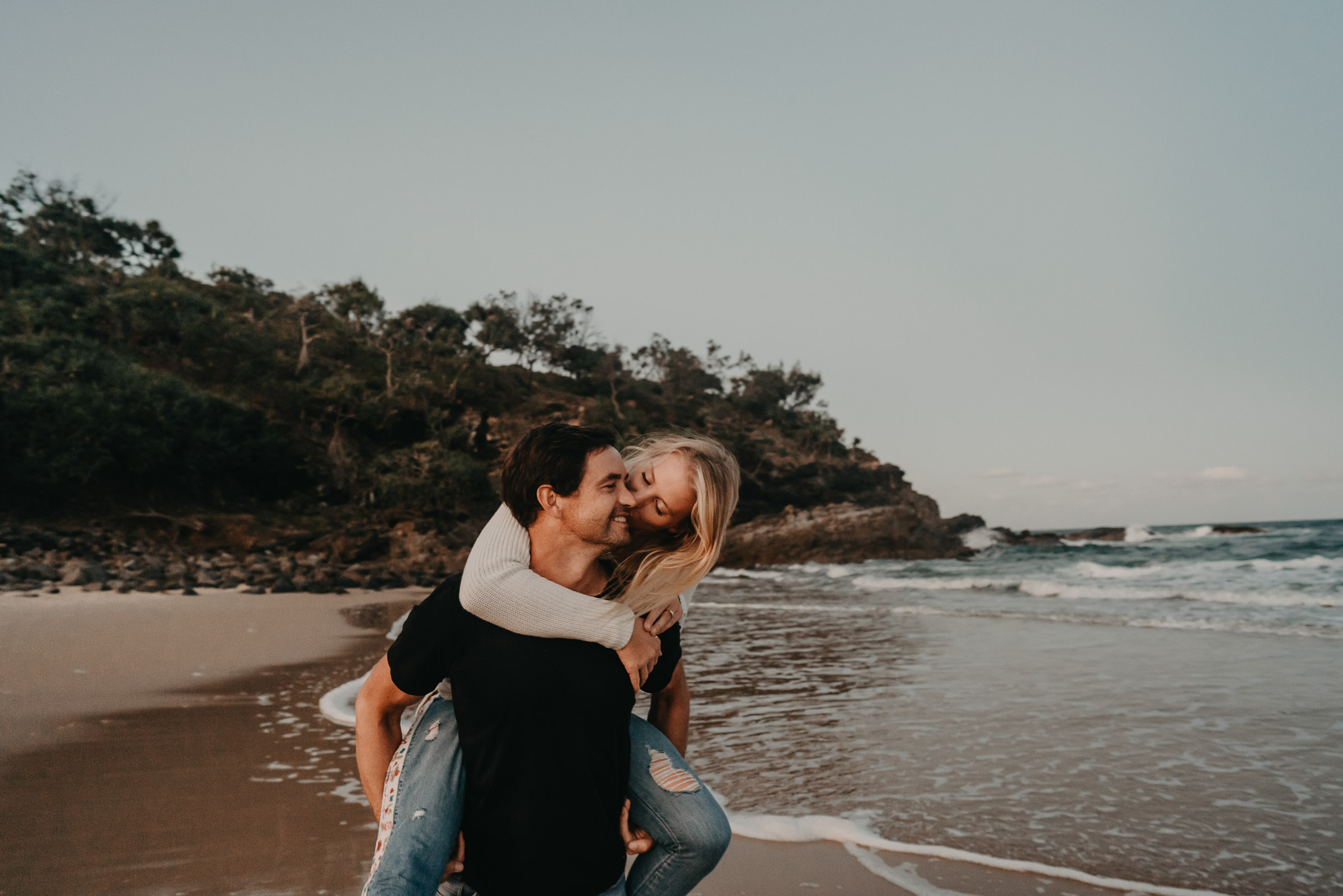 Couples cuddling during engagement shoot at Sunshine Beach